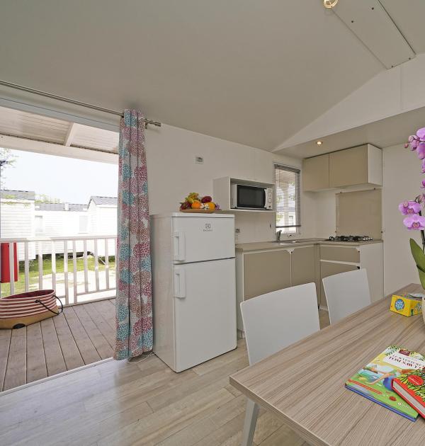 Modern kitchen with flowers and books on table.