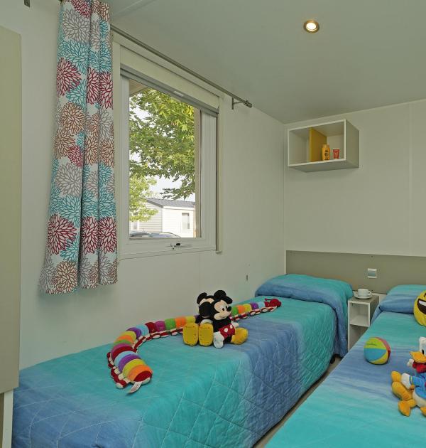 Room with two single beds and colorful toys.