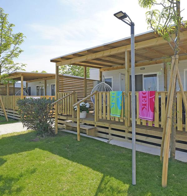 Moderne bungalow met houten veranda en tuin.