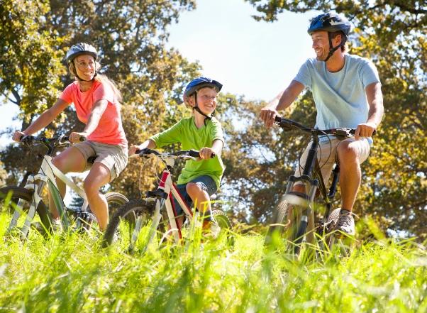 Famille heureuse faisant du vélo en plein air par une journée ensoleillée.