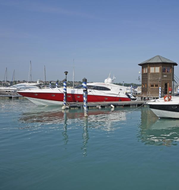 Yacht rouge au port avec tour de contrôle en bois.