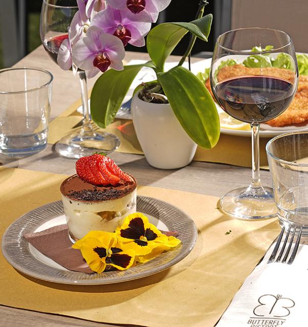 Table dressée avec dessert, vin et orchidée.