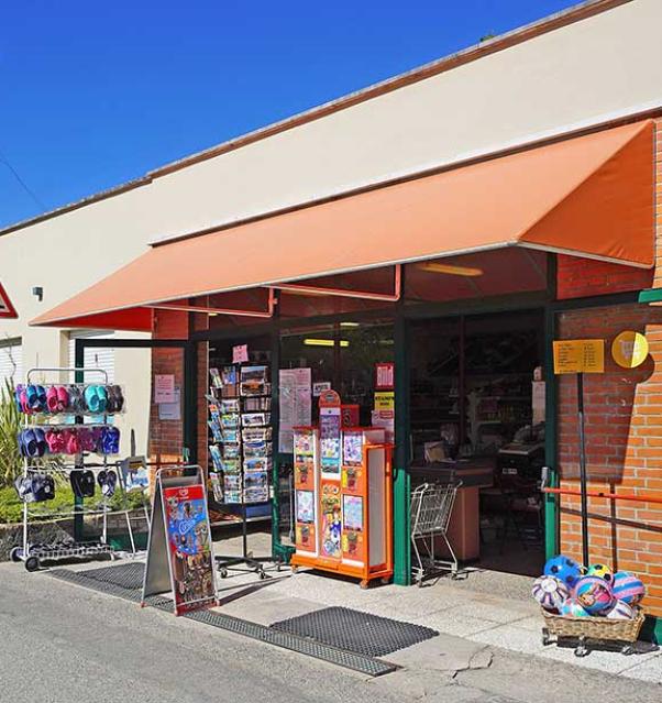 Winkel met zomerspullen en ansichtkaarten onder een oranje luifel.